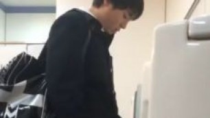 A male student is pissing in the toilet 1.